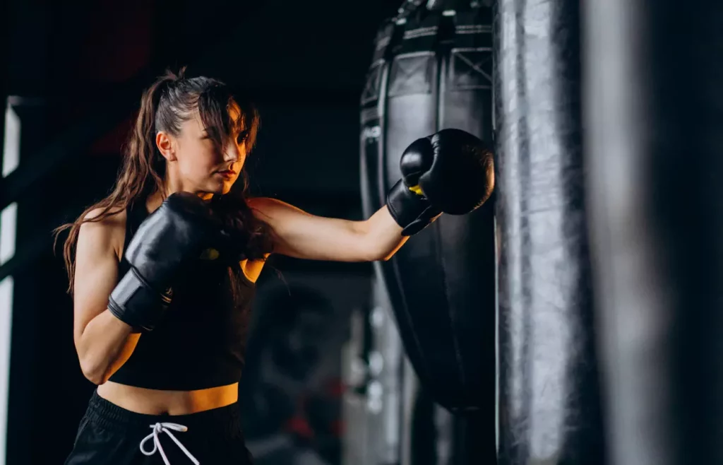 mulher praticando box na academia de lutas